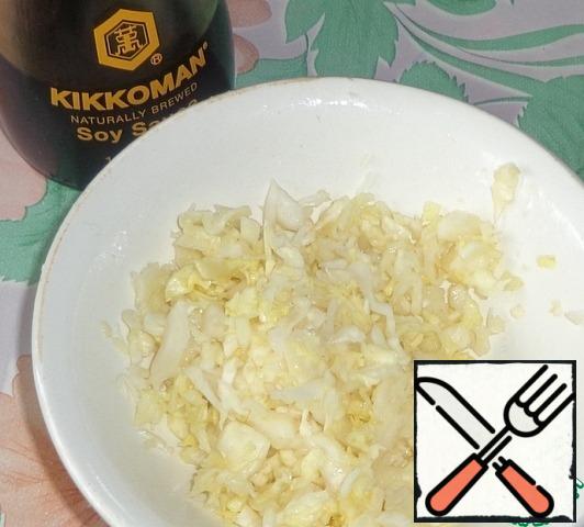 Rinse the white cabbage with water and finely chop. Mix soy sauce with vinegar and sugar. The resulting mixture is poured cabbage and thoroughly rubbed with hands. We leave it for the preparation of the salad.