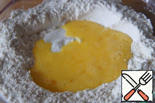 Add margarine and rub it with your hands in flour.
Pour sour cream and lightly beaten eggs,