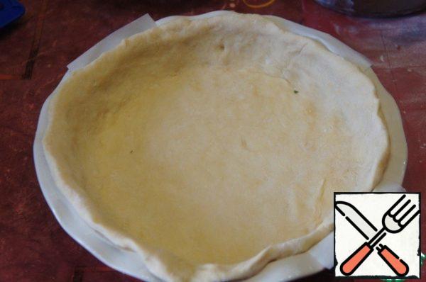 Divide the dough into two parts, one slightly larger. Roll out coarsely and place in a greased mold with a diameter of 23-24 cm .
