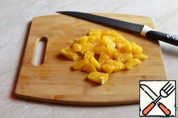 Peel the orange and cut into cubes.
