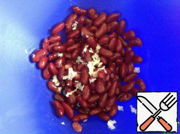 In a salad bowl, put the beans and garlic passed through a press.
