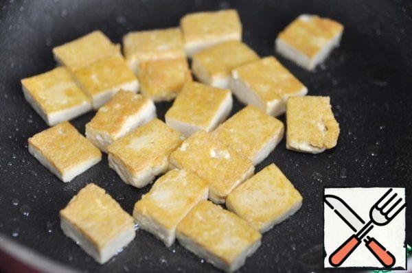 Pour vegetable oil into a frying pan and fry the tofu until golden brown on both sides, transfer to a plate.
