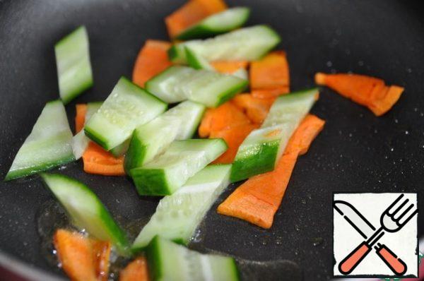 In a frying pan with the remaining oil, where the tofu was fried, put the carrots, fry for a couple of minutes, then the cucumber, fry for one minute. In Chinese cuisine, vegetables remain half-cooked, crispy.
