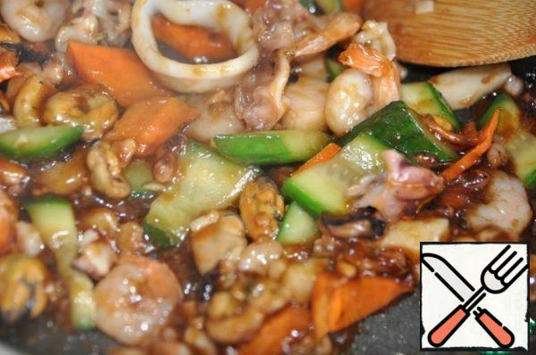 Pour the sauce over the vegetables with seafood, stir, the sauce will thicken immediately, simmer, stirring, for 1 minute.
