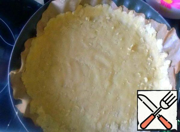 Let's make the dough for the base. RUB the softened butter with sugar. Add flour. From the resulting dough, we will mold the base in a baking dish, pre-covering it with parchment. Put it in the fridge for 30 minutes.