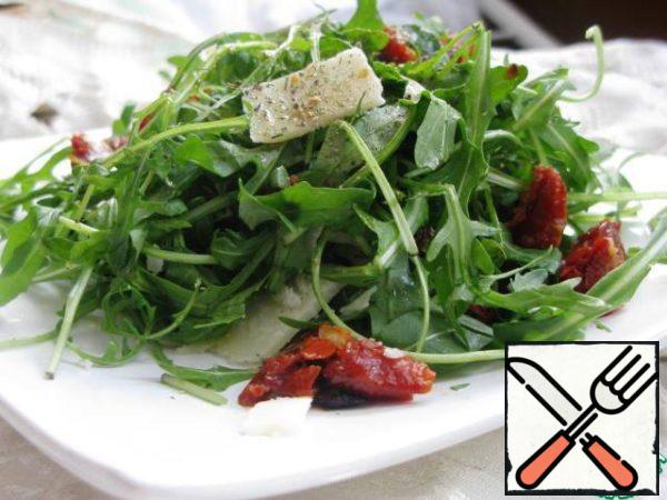 The arugula add the tomatoes, smash the cheese strips, mix well. Salt, add dried Basil and season with olive oil.