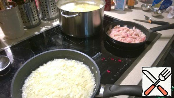 Peel the potatoes and put them to boil in salted water.
Cut the bacon into small pieces and put it to fry.
Finely chop the onion, also put it to fry, add salt. In the process of baking, squeeze garlic into the onion.