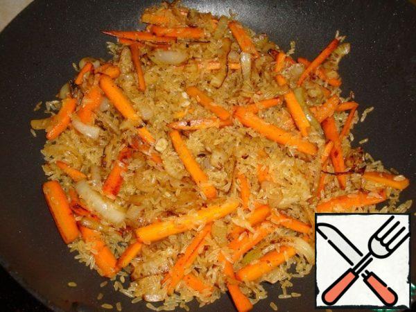 Then add the rice to the vegetables and fry it for a few minutes, stirring constantly. Then pour in the wine. Fry for another 3 minutes until the wine evaporates, stirring constantly.
