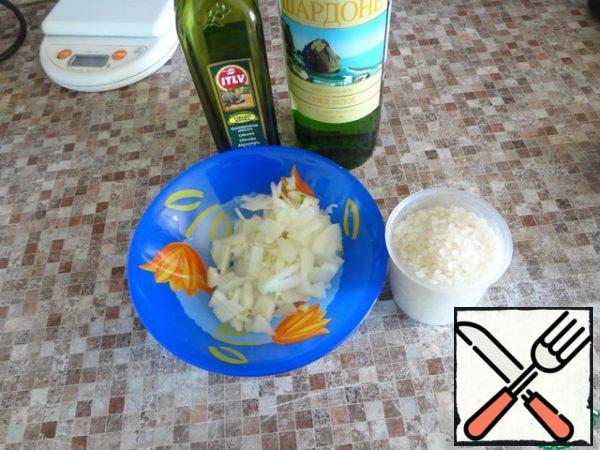 Prepare dry wine, olive oil, rice and chop a medium onion.
