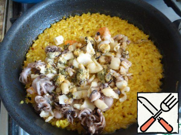 Put the seafood in the rice and cook for 3-5 minutes.
