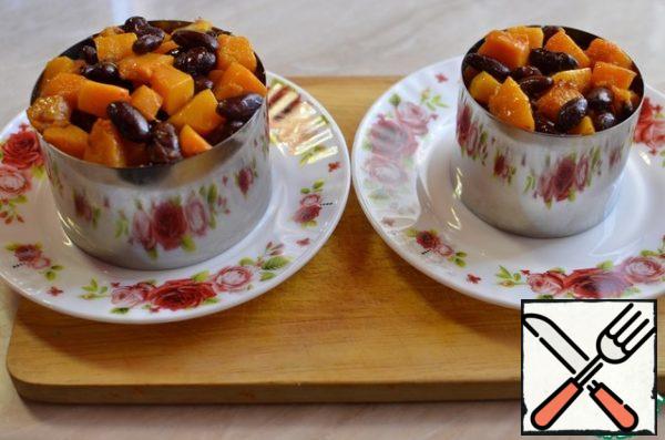 Put the pumpkin and beans on top. Lift the cooking rings as desired to decorate with greenery.

