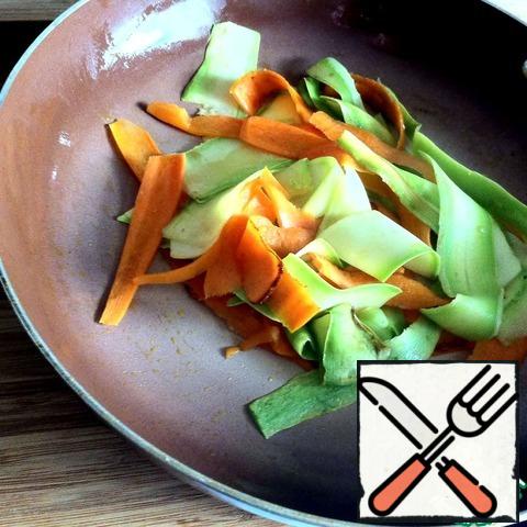 Carrots and zucchini cut into thin ribbons and fry for 2-3 minutes in vegetable oil.