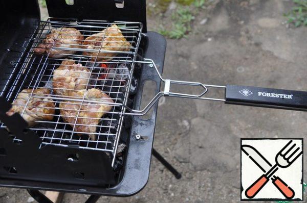 Raise the grill. When the coals are covered with a white patina of ash, put the grill on the grill. On the grill put the chicken thighs (without onions) skin down. Closing the bars.