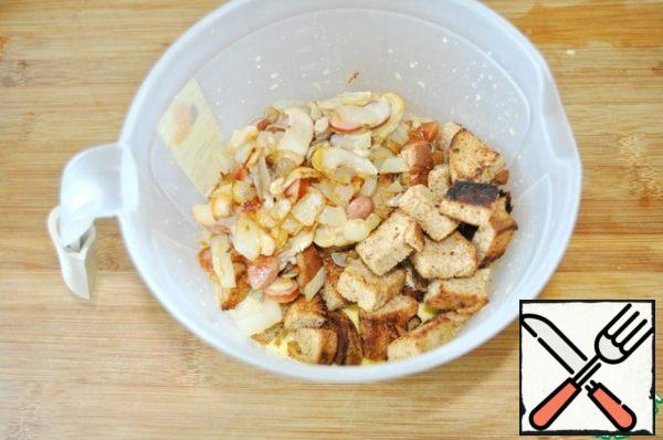 Add dried bread and fried mushrooms to the omelet mixture.

