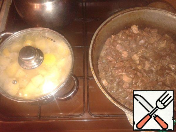 It's time to start cooking the side dish. Peel the potatoes, pour cold water, add salt and send them to cook on the stove. After boiling, put on a quiet fire and cook until tender. After the pork is slightly fried, open the lid and continue to simmer until the excess liquid evaporates. If there is not enough liquid and the meat begins to stick to the walls of the cauldron, you can add a little water. I can't say the exact time of cooking hot, it varies from 2 to 2.5 hours. Usually I try a piece of heart or lung, it should be easy to chew. I think that if you use less meat, they will reach readiness, but since I have a large family, I do not use less than 3-4 kg of products, and accordingly they cook longer.