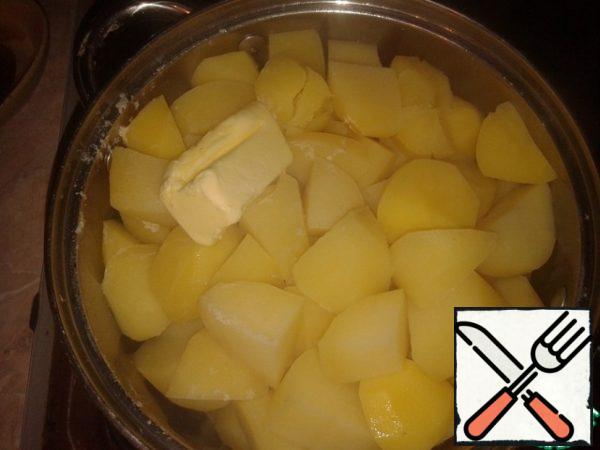 We've already cooked the potatoes. Drain the water from it, part of the liquid is about 200 ml., leave to dilute the puree. I drain the liquid from the potatoes when the main course is almost ready, so that the mashed potatoes do not have time to cool down before serving. I add butter and start grinding with a pusher.