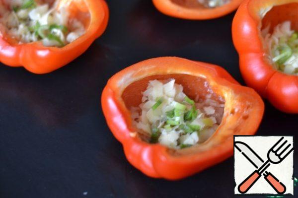 In the hot, baked pepper, put a little grated cheese on the bottom.
A pinch of onion.