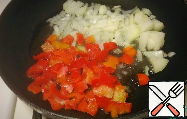 In a large pan for a couple of minutes sautéed in vegetable oil onion with diced bell pepper.