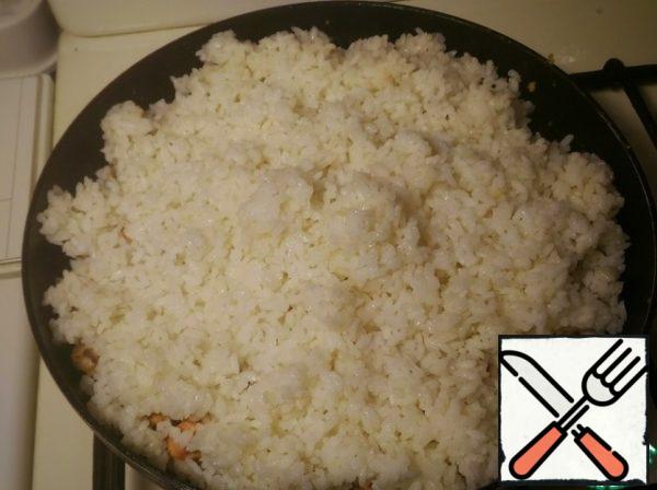 Next, spread on a pan our cooked rice.
Supplement with soy sauce and mix.