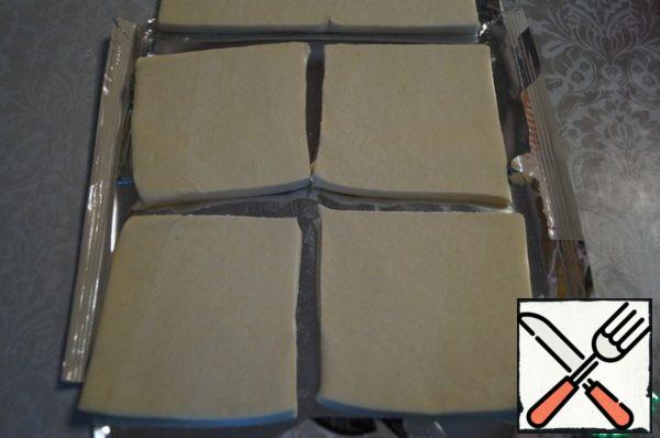 Defrost the dough.
As a rule, there are 2 layers of 250 g dough in a package.
Cut each layer into 4 squares.
In total, we will get 8 pieces.