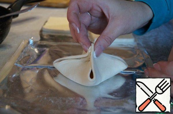 Lift up the corners of the dough squares and connect them crosswise. Pinching of seams.
