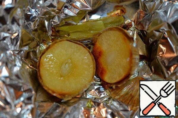 Cut the garlic in half, put it in foil, add the thick part of the green onion stalk, sprinkle with a tablespoon of olive oil. Wrap loosely to leave room for steam, and bake in a preheated 180 degree oven for 20 minutes.
