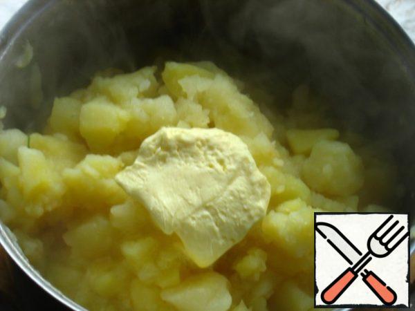 Cook the potatoes over medium heat for about an hour, so that they boil hard, and most of the water boils away. Do not flush the water! Add the butter.
