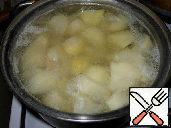First peel, slice and boil the potatoes in salted water until they are soft.
