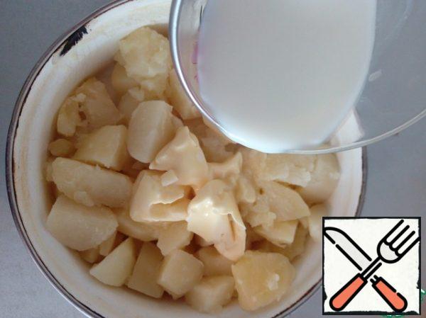 When the potatoes are ready, drain the water. Pour the milk into a glass and send it to the microwave for 2 minutes to boil. Add boiled milk and butter to the pot with potatoes. I always cook mashed potatoes only with a mixer, so it turns out very tender, airy and homogeneous (like cream). This method eliminates the presence of lumps in the puree.

