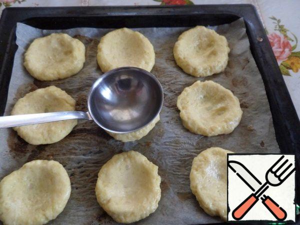 Spread the potato cakes on a baking sheet covered with parchment. With the help of spoon make small holes. Each time, wetting the ladle with water.