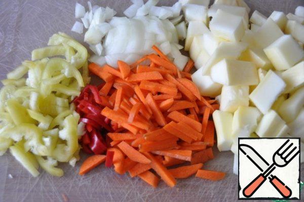 Wash and peel the vegetables. Cut carrot, bell pepper and hot pepper into thin strips. Cut the onion and zucchini into cubes.
