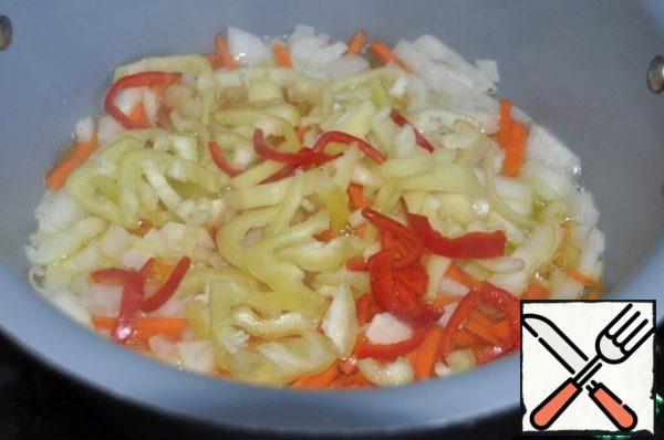 Pour oil into a cauldron or saucepan, heat up, put onions and carrots and fry over medium heat until the onion is transparent for a couple of minutes, put Bulgarian and hot pepper. Fry and simmer for three minutes over medium heat.

