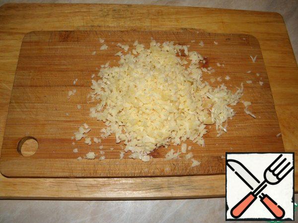 Grate the cheese on a coarse grater.
