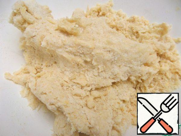 Pour in a spoonful of cold water (or milk, or whey) until the dough begins to gather into a lump.
