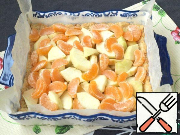 Cut the apples into 4 pieces, remove the skin and cut into slices about 5 mm thick. Divide the tangerines into slices. Put the fruit on the baked cake.
