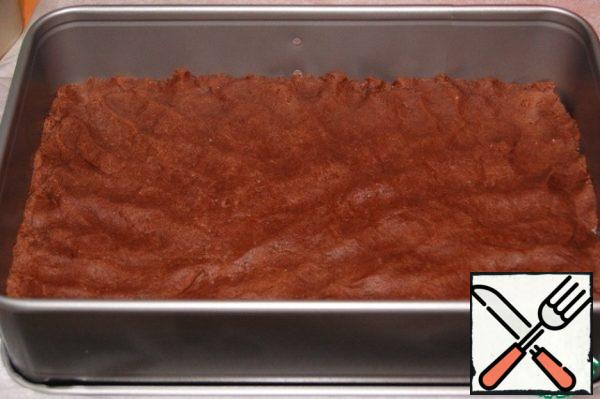 The greater part distributed in the form of 28х20 cm, the bottom of which lay a baking paper. Put the form with the test for 30 minutes in the refrigerator.
Bake the chilled cake in a preheated 190*C oven for about 20 minutes. Focus on your oven!
