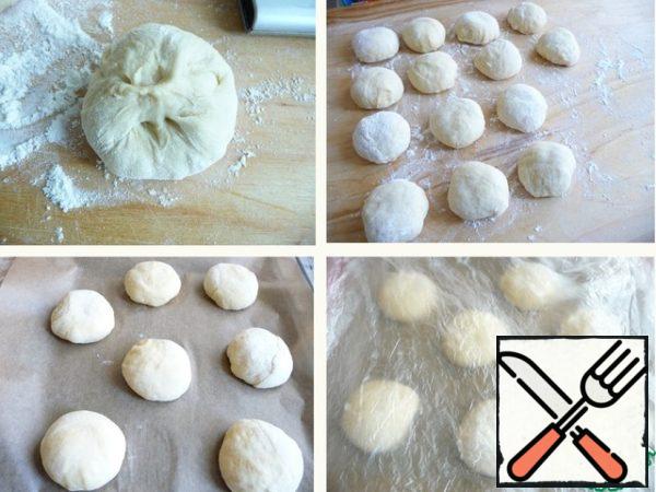 Roll the dough balls, pulling the ends of the dough to the center (at I have14 PCs 77 g).
Baking sheet with baking paper.
Put on it the balls in the distance.
Cover with foil and leave it for 20min. dough to rise.