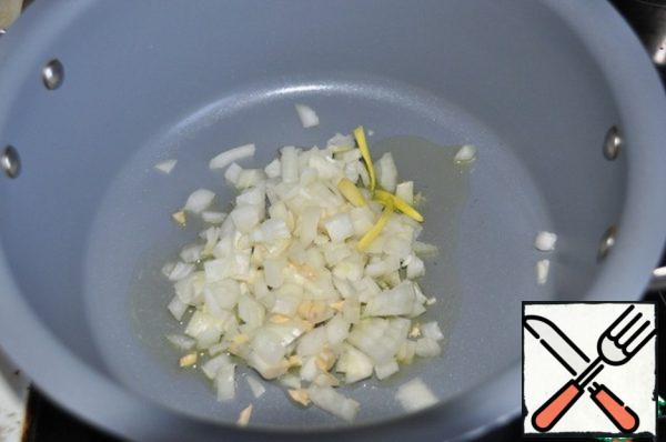 Onions and garlic cut into small cubes and fry for 1 minute on high heat in vegetable oil in a saucepan.