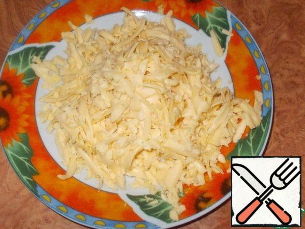 Grate the cheese on a coarse grater.
