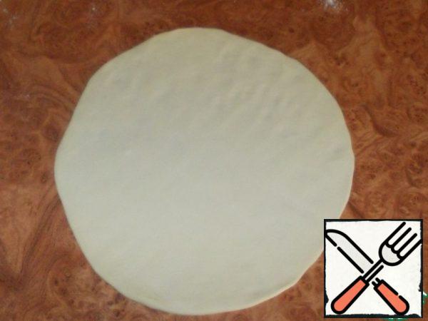 Take one lump and roll it into a thin round cake.
