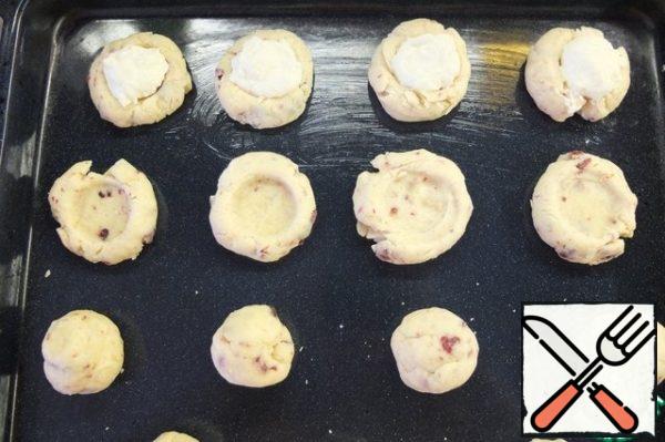 Grease the pan with butter.
Roll small balls out of the dough, I turned out to be about like ping-pong balls.
Spread on a baking sheet. In the center of each ball, make a recess, I did it with a potato masher. Put about 1 tsp of filling in the recess. I got 15 pieces.