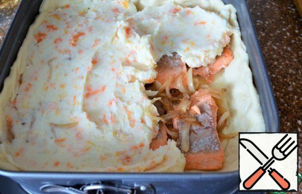Put half of the fried onion on the dough,
put the fish, the remaining onion,
then mashed potatoes.