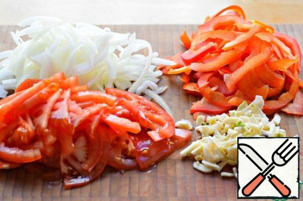 Tomatoes, onions and peppers cut into half rings. Chop the garlic.
