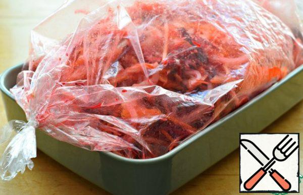Tie both ends of the sleeve and shake it well. Thus, all vegetables are mixed together, and salt, oil and spices are evenly distributed over the vegetable mass.
Put the sleeve in a baking dish, make several punctures in it so that air circulates in the sleeve during baking.