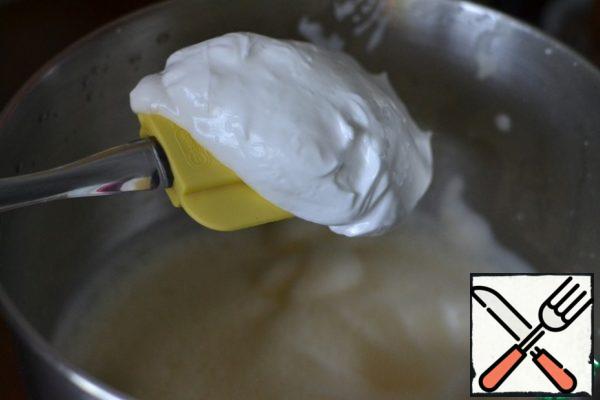 In a separate bowl, beat the whites with the remaining sugar to steep peaks.
Add to the yolk mass and mix with a spatula.