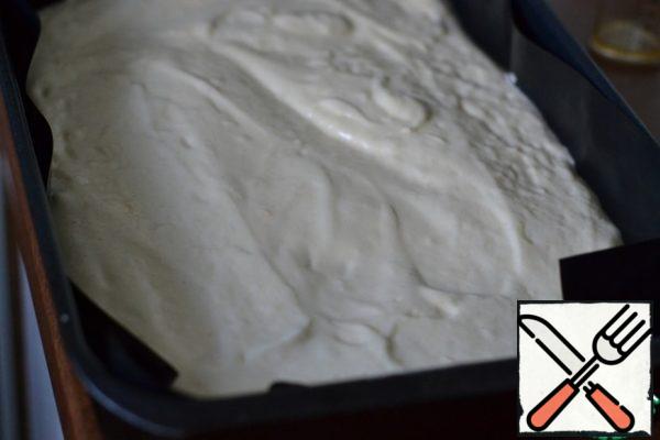 Mix flour with baking powder and add parts to the egg mixture. Mix with a spatula, gently and quickly. Pour the sunflower oil and mix well.
35*25 the form to lay baking paper.
Spread the dough in a mold.