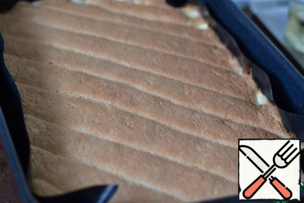 Bake in a preheated 180*C oven for 30 minutes.
Cool the finished cake on the grill, removing the paper.
The dough rose between the pudding strips, and the filling was in the middle!