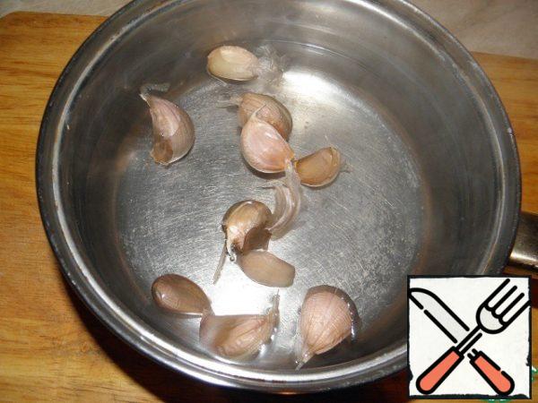 While our potatoes are cooking, we will prepare garlic: boil about 200 ml of water in a ladle, put the garlic heads disassembled on the teeth. Before that, do not remove the husk. Cook for a couple of 1-2 minutes and immediately flip into a colander

