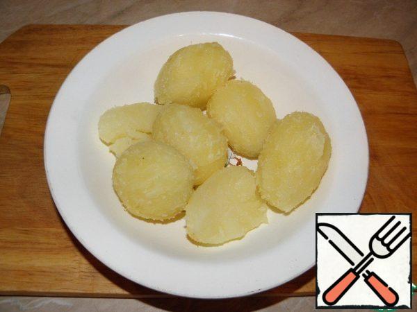 Then peel the potatoes, I try to clean it in a very warm state, and in General the potatoes are cooled, wrapped in a towel.