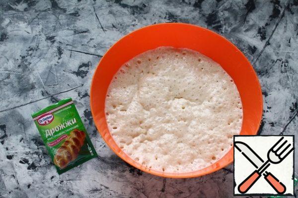 Cook:
Pour yeast into warm water (no more than 37 g), add 1 tablespoon of sugar (of the total amount) and flour (5-6 tablespoons of the total amount). It should turn out to be quite thick, lazily slipping off the spoon of sourdough.
Cover the bowl and leave it in a warm place to rise. This can take anywhere from 30 to 50 minutes. When the dough begins to settle, it means that it is ready.